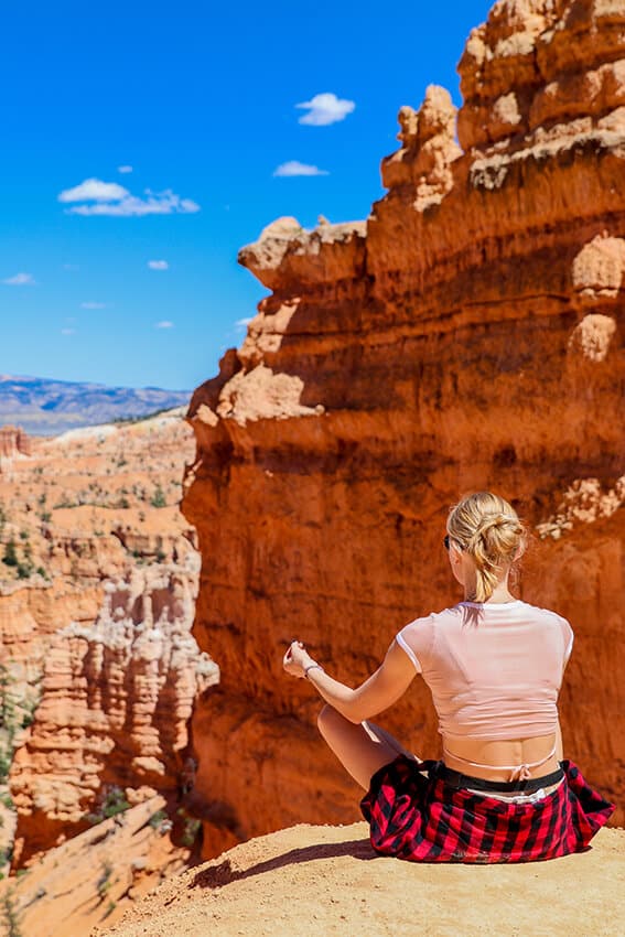 Girl meditating at Bryce National Park on a Utah road trip