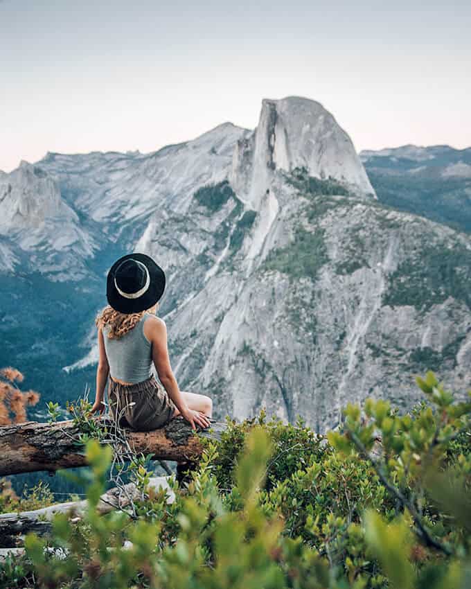 Ragazza seduta su un tronco si gode il panorama a Zion