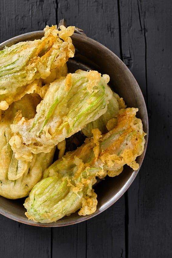 Ciotola in acciaio con fiori di zucca ripieni alla napoletana