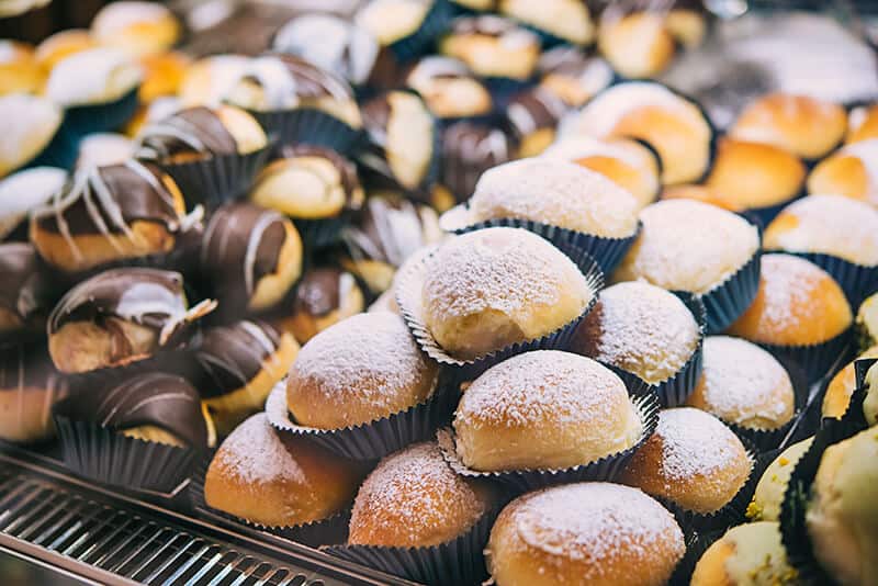 Sfogliatella frolla with powdered sugar and with chocolate custard on the top