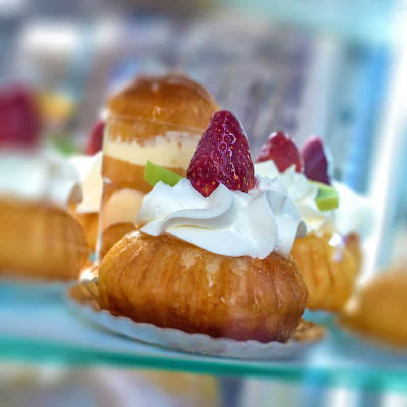 Neapolitan babà pastry with whipped cream and fresh strawberries