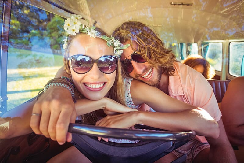 Smiling couple on a babymoon on a budget in a campervan