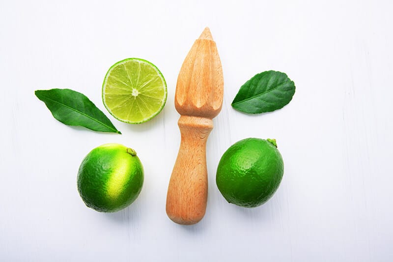 Koa wood juicer with two green lemons