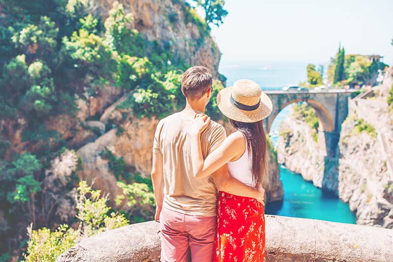 Young couple on honeymoon in Southern Italy watch the Furore fjord on the Amalfi Coast