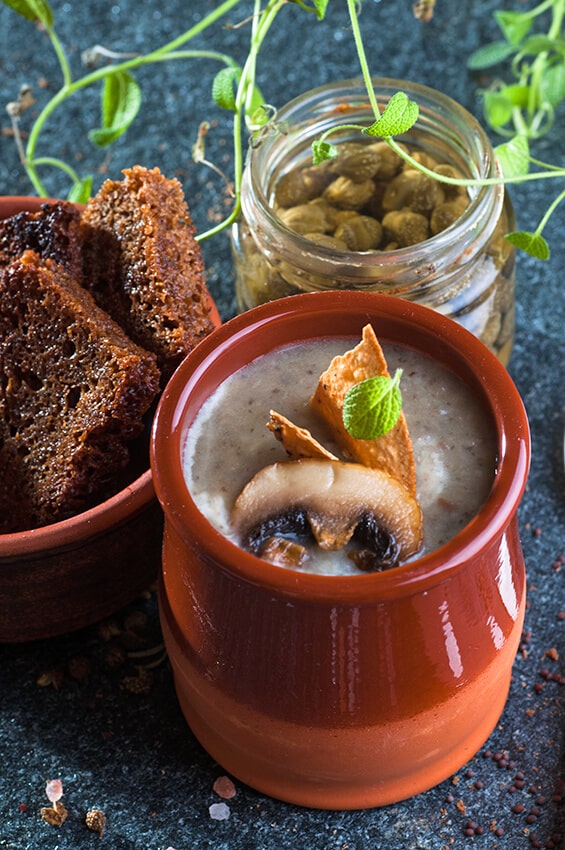 Vasetto di zuppa di funghi e piccole fettine di pane integrale 