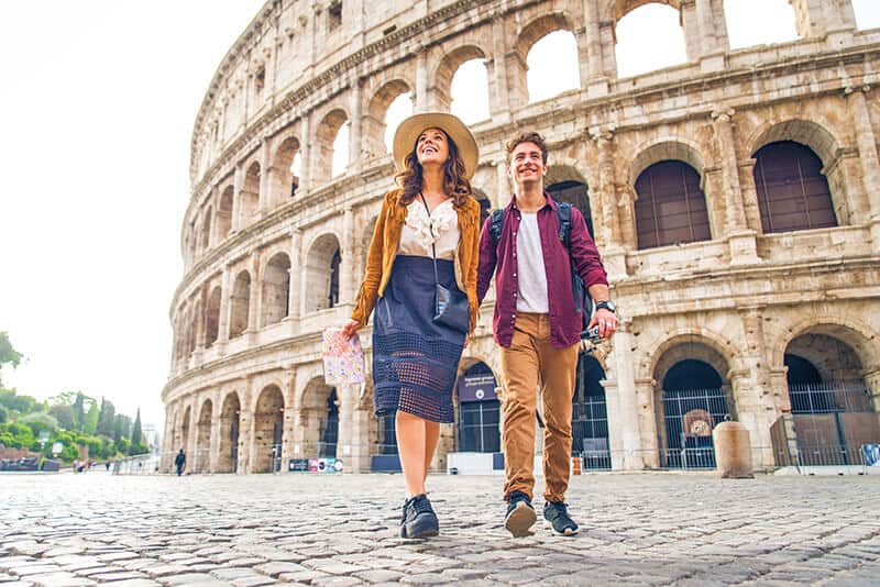 Giovane coppia a passeggio davanti al Colosseo a Roma