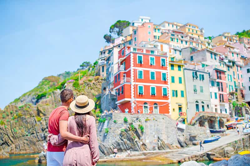Coppia in viaggio di nozze in Italia osserva le casette colorate alle Cinque Terre