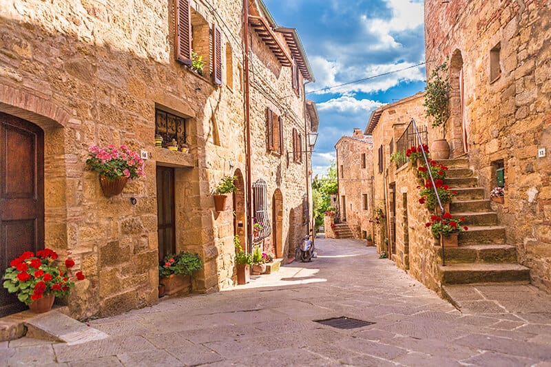 Romantic stone village in Italy in spring with flower pots everywhere