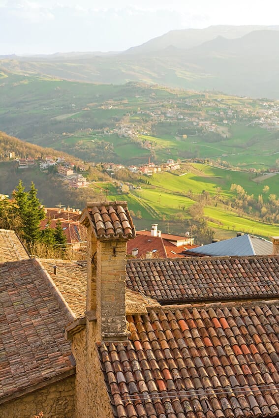 Tetti di case in Toscana con vallate verdi sullo sfondo