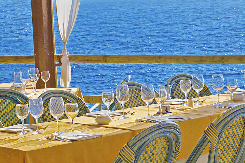 Tavolo di un ristorante apparecchiato con vista mare a Bacoli