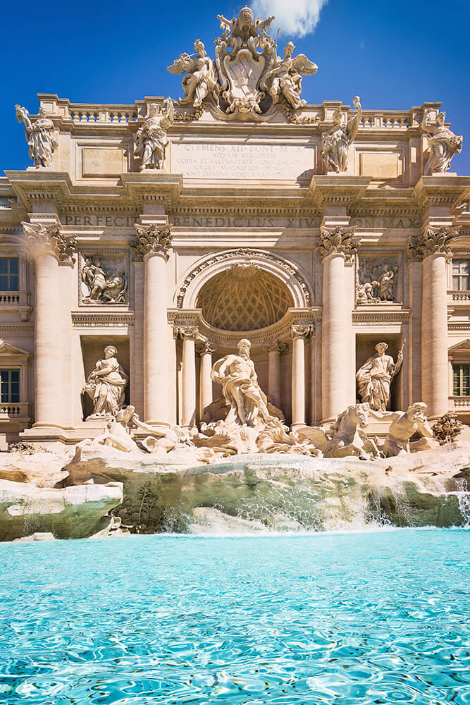 Trevi Fountain in Rome with marble statues and a blue pool of water
