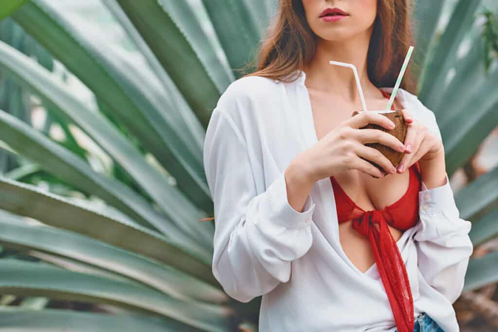 Girl drinking a cocktail on a rooftop bar in Miami