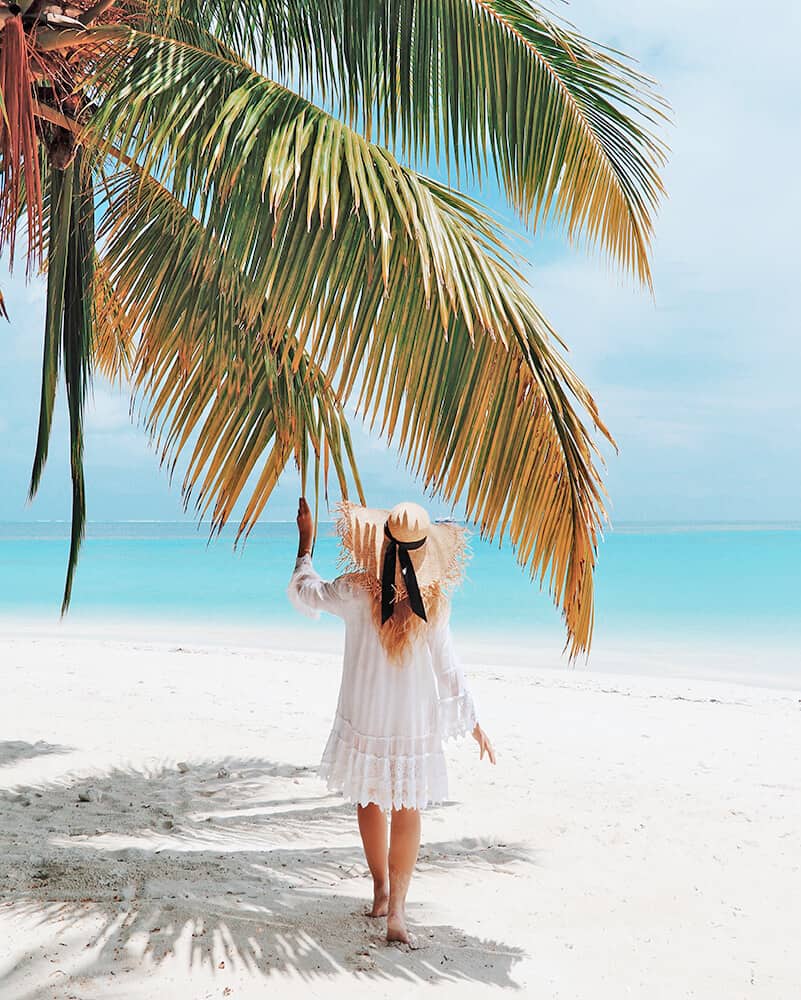 Ragazza tocca una palma in spiaggia a Miami Beach