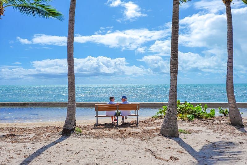 Couple of elders sitting next to the ocean in Miami