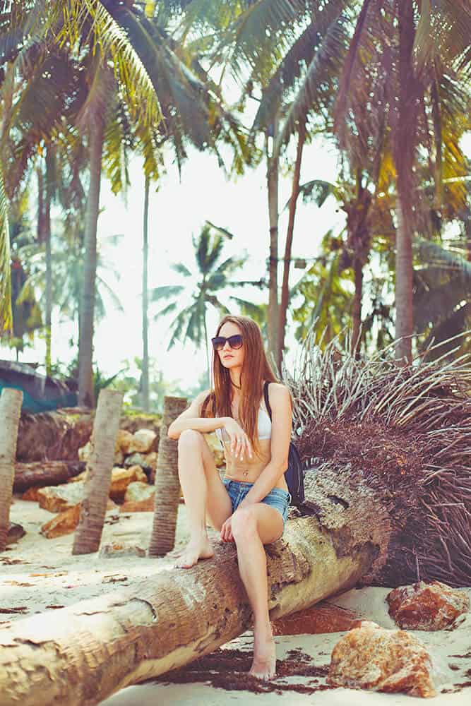 Young woman sitting on a palm in Miami Beach