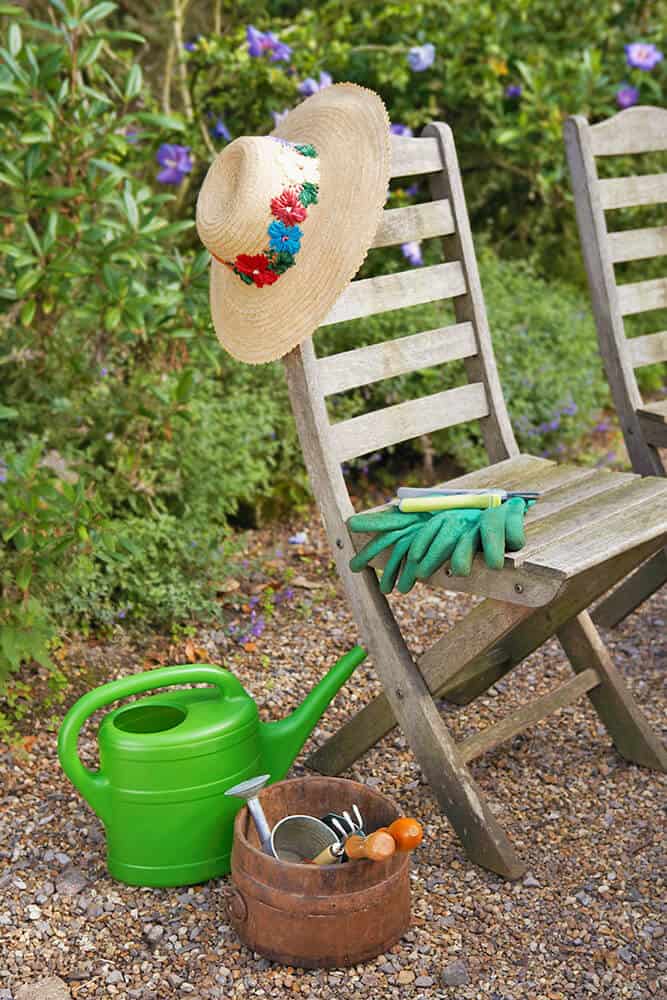 Attrezzi da giardinaggio, un cappello e una sedia