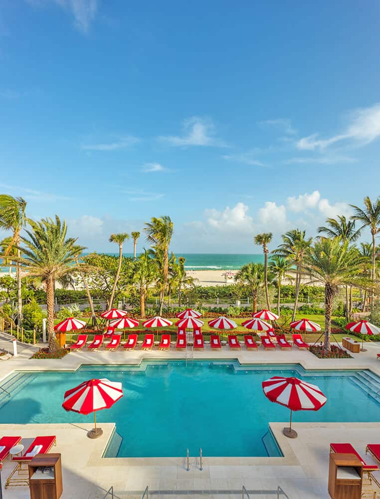 Red and white umbrellas near the swimming pool at the Faena Hotel in Miami Beach