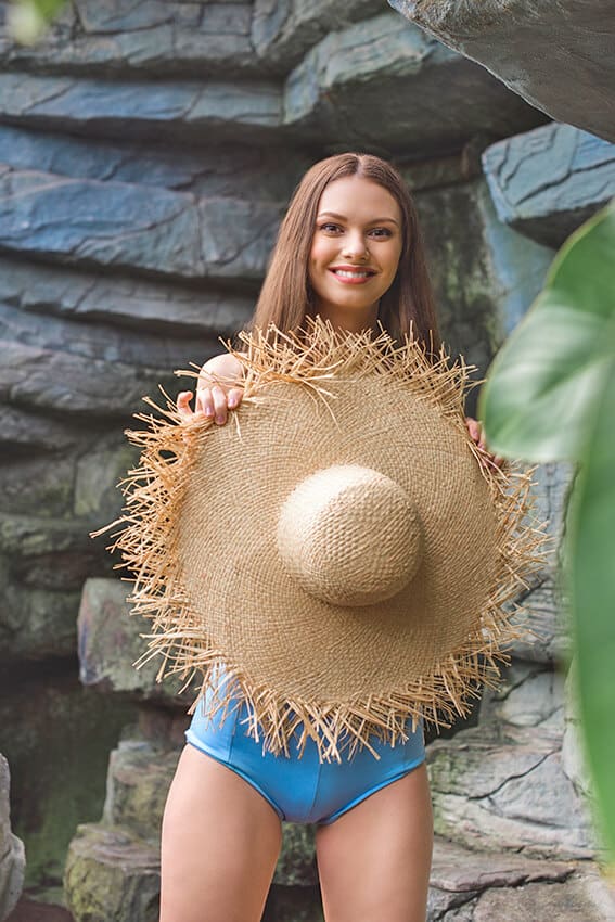 Woman holding a floppy straw hat