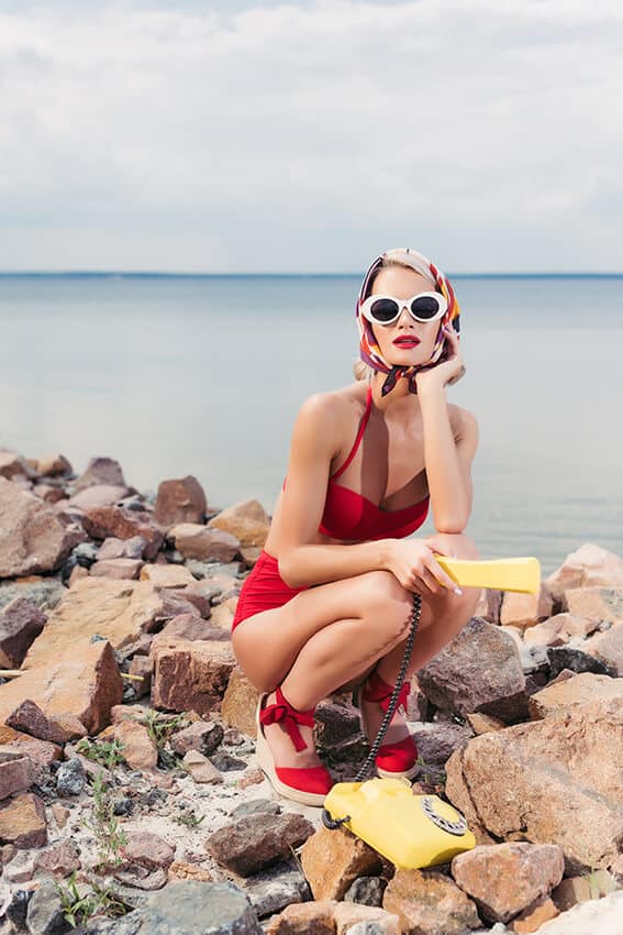 Donna in spiaggia con un telefono