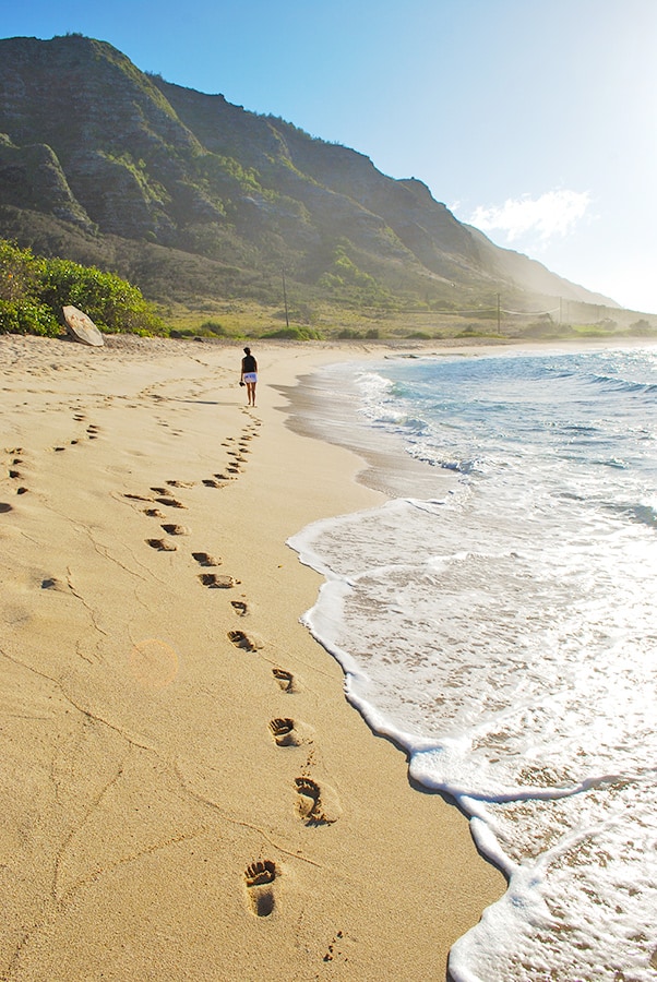 Donna passeggia a piedi su una spiaggia a Oahu