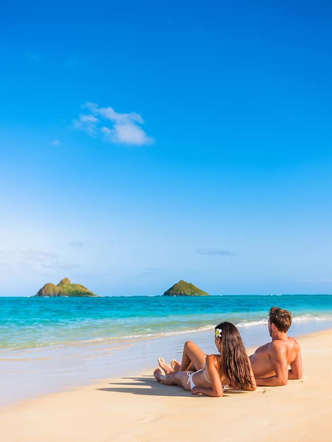 Couple laying on a scenic beach in Oahu