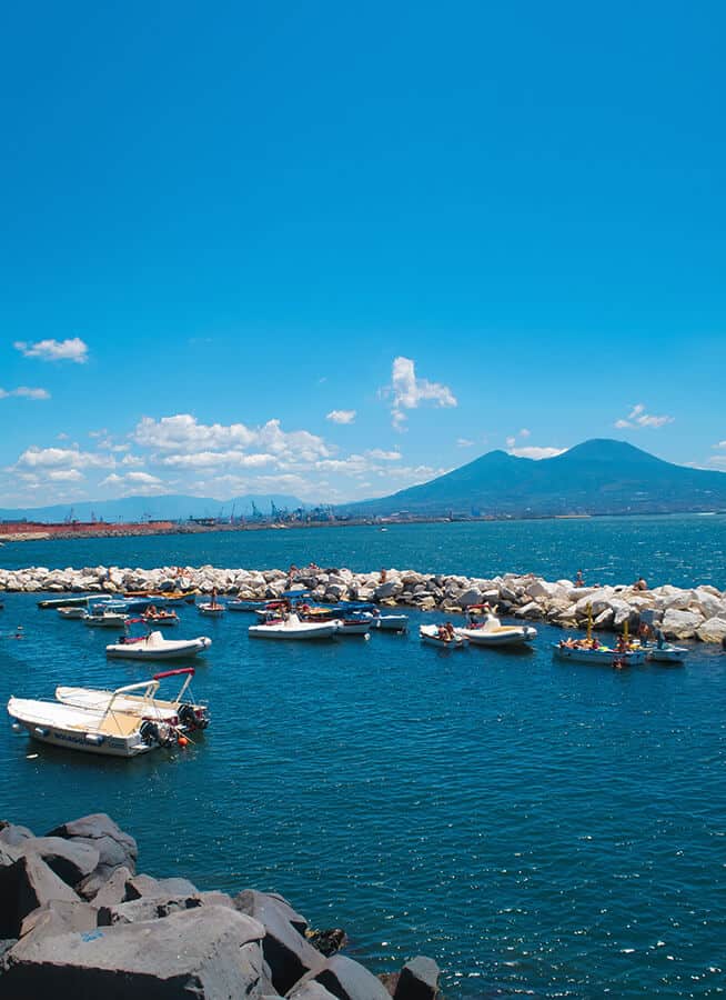 Small boats with Mount Vesuvius in the background