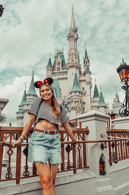 Woman posing in front of Cinderella Castle in Orlando