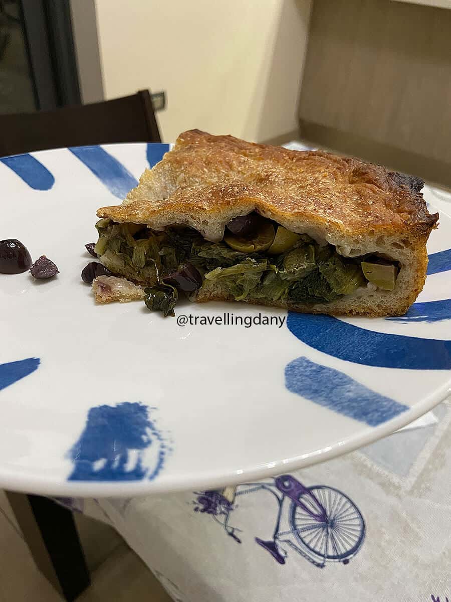 A slice of pizza di scarole with olives