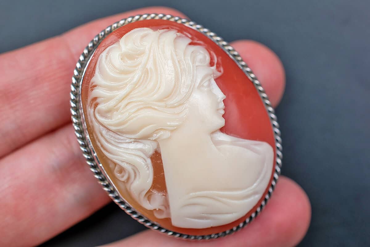 Hand holding a cameo brooch