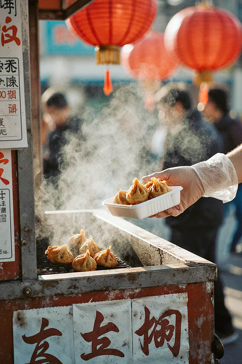 woman serving fried dumplings in NYC Chinatown