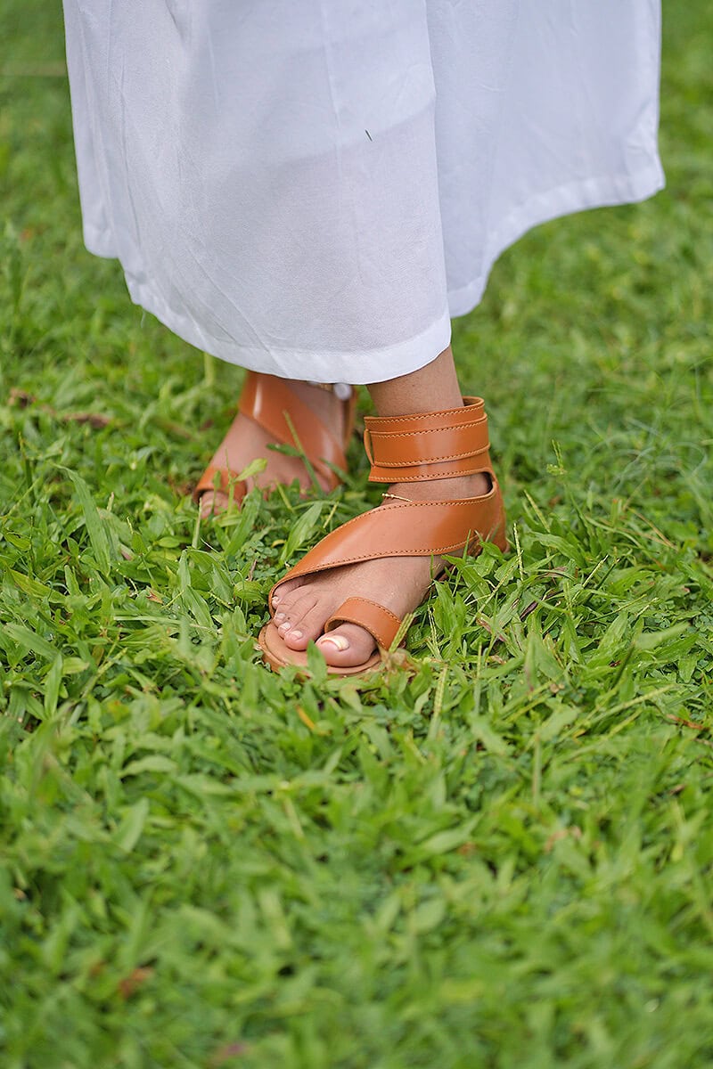 Woman wearing handmade leather sandals on a lawn