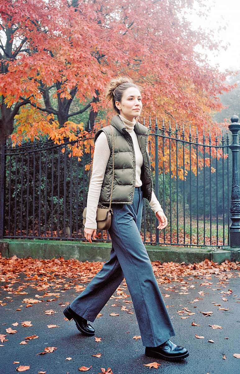 Woman walking in Central Park in Autumn wearing a puffer jacket